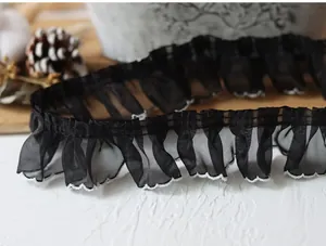 Detailed close-up of 4cm black pleated lace trim with white scalloped edges for DIY sewing