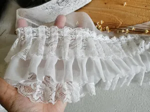 Dettaglio del bordo in pizzo di chiffon bianco a tre strati plissettato per balze e polsini