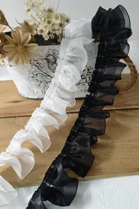 Detail of 4cm wide pleated lace trim in black and white for garment sewing crafts