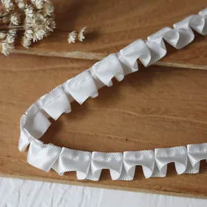 Close-up of white ruffled ribbon lace trim with elegant pleats for doll clothing