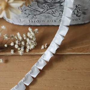 Macro shot of white pleated satin ribbon trim for DIY sewing and doll clothing