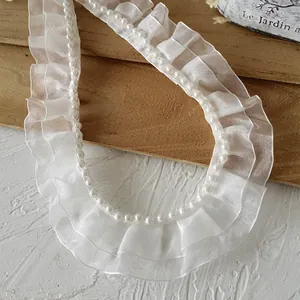 Detailaufnahme von weißer doppellagiger Organza-Spitze mit Perlen für Bekleidung