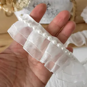 Detailansicht weißer Falten-Chiffonband mit eleganten Perlenverzierungen für Kleider