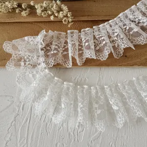 Detailed view of white ruffled lace trim with floral patterns for garment sewing and DIY