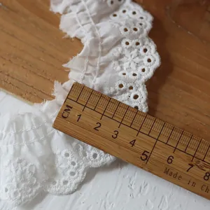 Gros plan de la bordure en dentelle de coton blanche de 4 cm avec broderie plissée