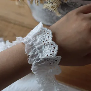 Gros plan de manchettes en dentelle de coton blanc avec broderie florale raffinée