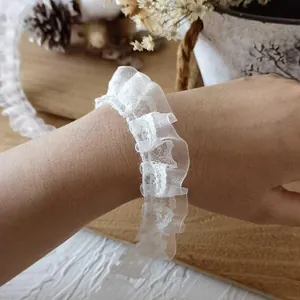 Detailed view of white pleated lace trim ruffle on wrist for DIY sewing and doll clothing