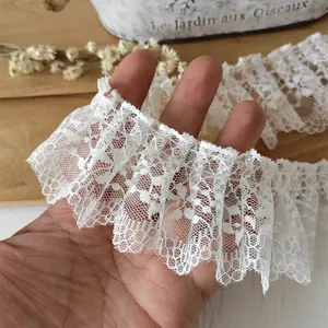 Close-up of pleated white lace trim with floral embroidery for DIY sewing crafts