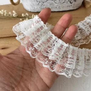 Détail de la bordure en dentelle blanche plissée à double couche avec broderies florales