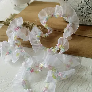 Close-up of 2cm elastic white mesh lace with vibrant colorful stitched ruffle edges