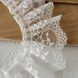 Close-up of white lace trim with floral hollow patterns and honeycomb texture