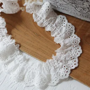 Détail de dentelle en coton blanc de 4cm avec bordure à volants sur plateau