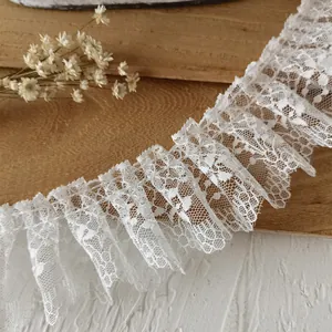 Macro view of white pleated lace trim with delicate floral mesh and wavy edges for doll clothes