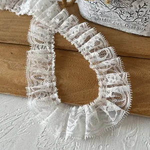 Close-up of pleated white lace trim with intricate floral mesh for DIY sewing and doll clothes