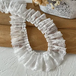 Close-up of white pleated lace trim with floral mesh patterns for DIY clothing decor