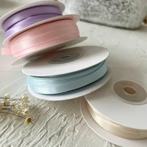 Nastri di raso color pastello su rotoli bianchi per confezioni regalo e decorazioni fai da te