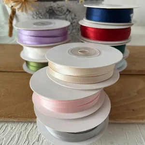 Rotoli di nastri di raso colorati per artigianato fai-da-te su fondo legno naturale