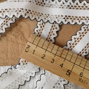 Macro view of 2cm white elastic lace ribbon with black scalloped edge for DIY sewing