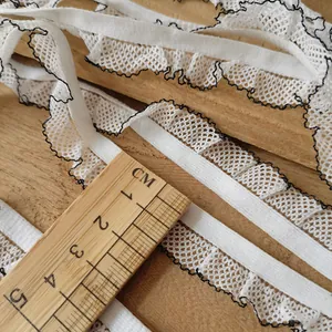 Macro detail of 2cm white elastic lace ribbon with black wave trim on wooden background