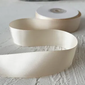 Détail d'un ruban de satin ivoire de 2,5cm avec texture soyeuse pour emballages cadeaux