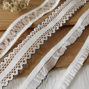 Detail of four styles of white elastic lace ribbons for sewing and DIY craft projects