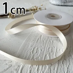 Detalle de cinta de raso crema de 1cm de ancho con textura de seda suave para manualidades