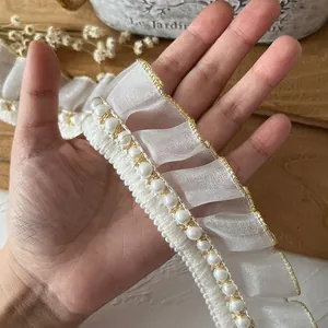 Pizzo in organza plissettata bianca con bordo in filo d'oro e perle per il cucito