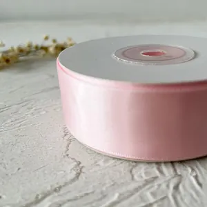 Gros plan sur un ruban de satin rose pour emballage cadeau et loisirs créatifs