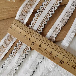 Various white elastic lace ribbons on wooden background for DIY sewing and crafts