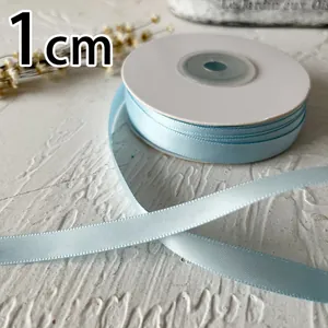 Detalle de cinta de raso de doble cara azul claro de 1cm con textura suave y brillo