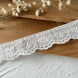 Pizzo in cotone bianco ricamato con motivi floreali e bordi ondulati per il cucito DIY