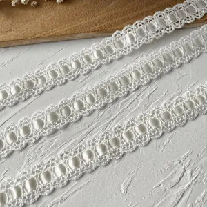 Dettaglio di pizzo in cotone bianco con nastro di raso per cucito fai-da-te e decorazioni