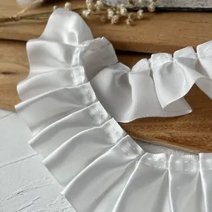 Ruban de dentelle plissée blanche de 5cm pour couture DIY sur fond en bois naturel