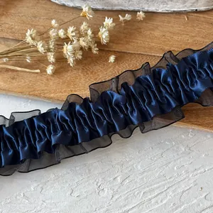 Detailed view of navy blue pleated satin lace trim for DIY garment crafts and accessories
