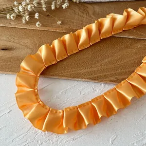 Detail of bright orange ruffled satin lace ribbon for DIY garment and hem decoration