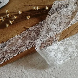 Close-up of white eyelash lace ribbon with floral mesh and scalloped edges for DIY crafts