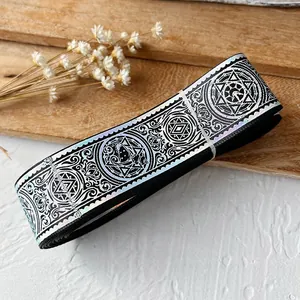 Macro view of holographic silver jacquard ribbon with hexagram moon patterns for DIY crafts
