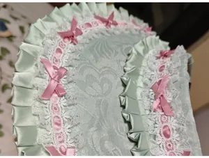 Detalle macro de encaje Lolita verde menta con lazos rosas y cintas de satén plisadas