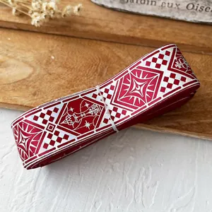 Detail view of vintage red and white checkered ribbon roll with geometric patterns