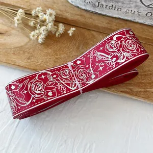 Primer plano de cinta roja con motivos de rosas y aves para decoración de manualidades
