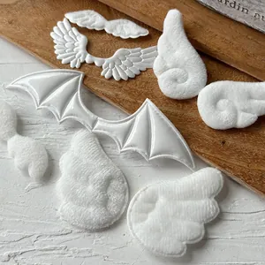Macro shot of white plush angel wings and shiny PU devil wings for DIY craft decor