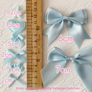 Detailed view of light blue satin ribbon bows in various sizes for DIY craft decorations