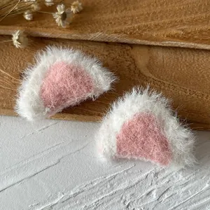 Nahaufnahme von weiß-rosa Plüsch-Katzenohren für DIY-Haarspangen und Bastelarbeiten