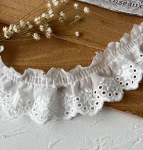 Witte katoenen kant met ruches en delicaat oogjes borduurwerk voor kleding en hobby