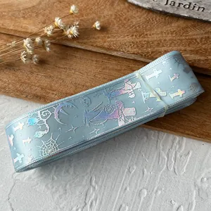 Close-up of light blue satin ribbon with holographic silver cross and spider web patterns