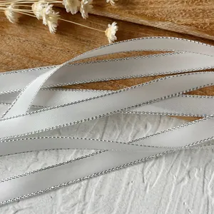 White polyester ribbon with silver glitter edges and diagonal texture for DIY crafts