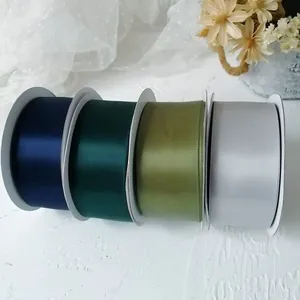 Close-up of 4cm wide double-sided satin ribbons in four elegant silk colors on reels