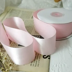 Detail of light pink 4cm double-faced polyester satin ribbon with silky pearl luster texture