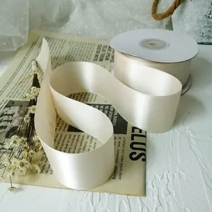 Close-up of premium champagne satin ribbon rolls for wedding gift wrapping and DIY crafts