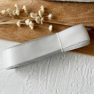 Roll of premium white polyester satin ribbon with decorative silver metallic edges